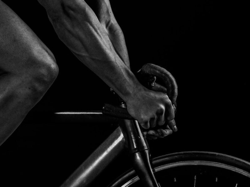 Svartvit närbild av cyklistens händer på ett bockstyre